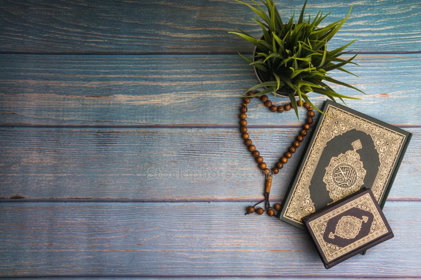 Flat lay view of vase, tasbih or rosary beads and Holy book of Quran with arabic calligraphy