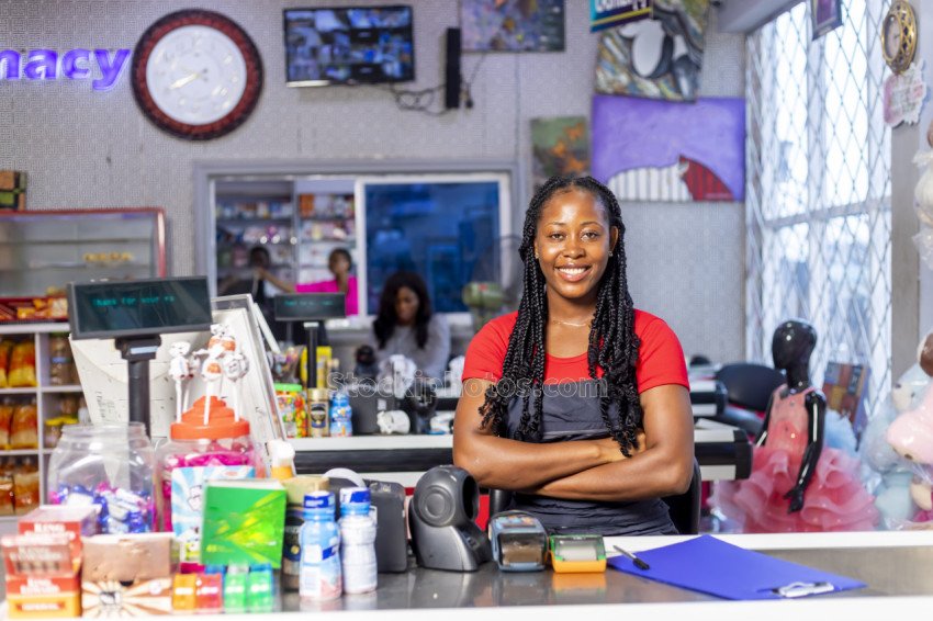 smiling african american woman black apron as cashier cash register