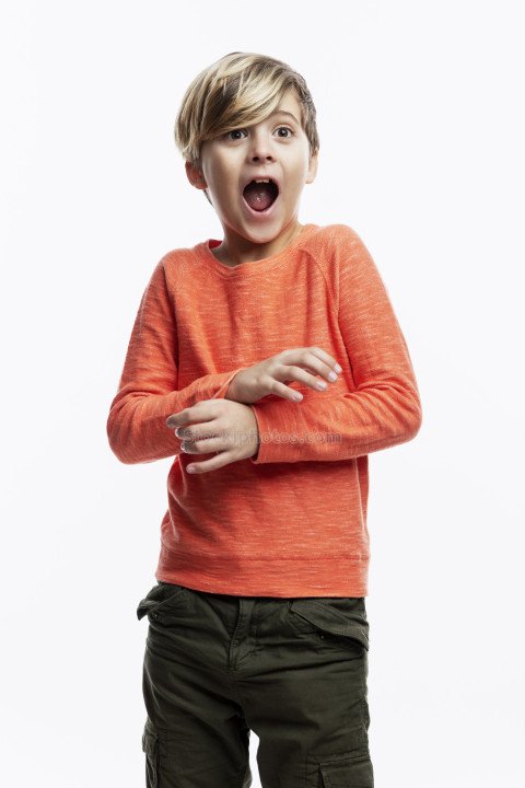 A 9-year-old boy in an orange sweater and jeans shouts in fright